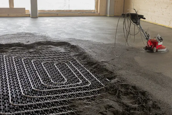 Frisch eingebrachter Estrich über einer Fussbodenheizung auf der Baustelle